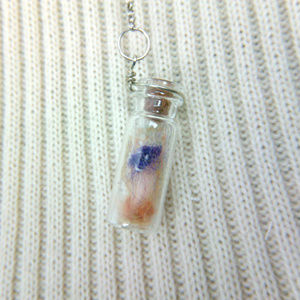 Miniature bottle with purple mushroom and spores